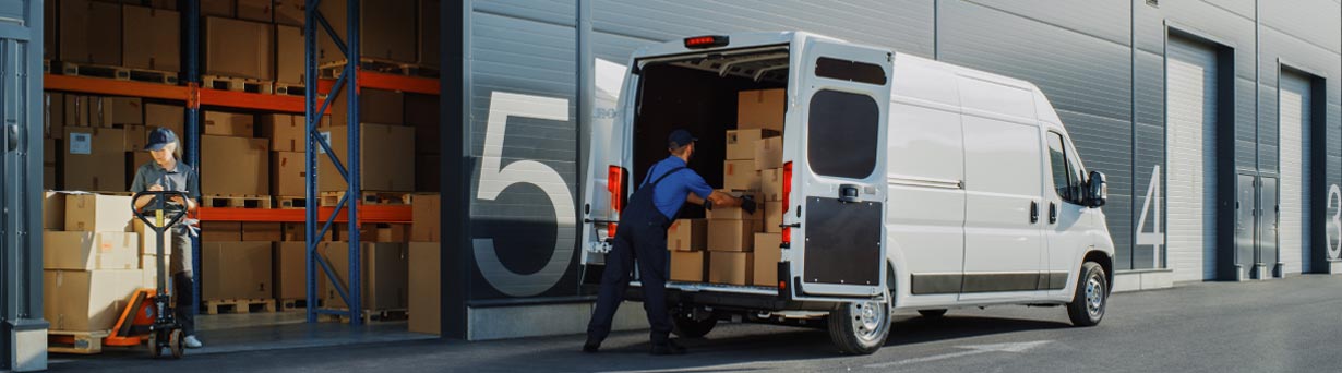 Employee stocking cargo van with boxes at warehouse with asset tracking and condition monitoring