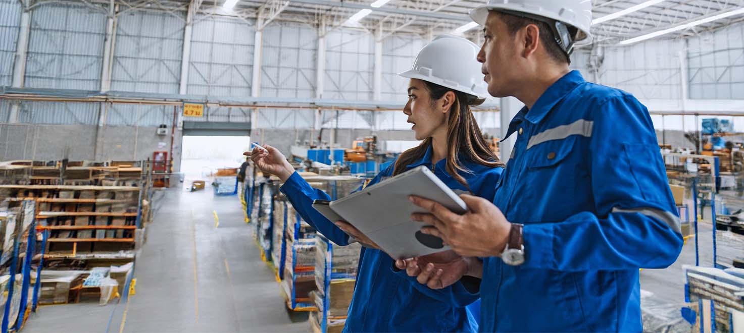 Warehouse employee working on a laptop to track, monitor and manage assets.